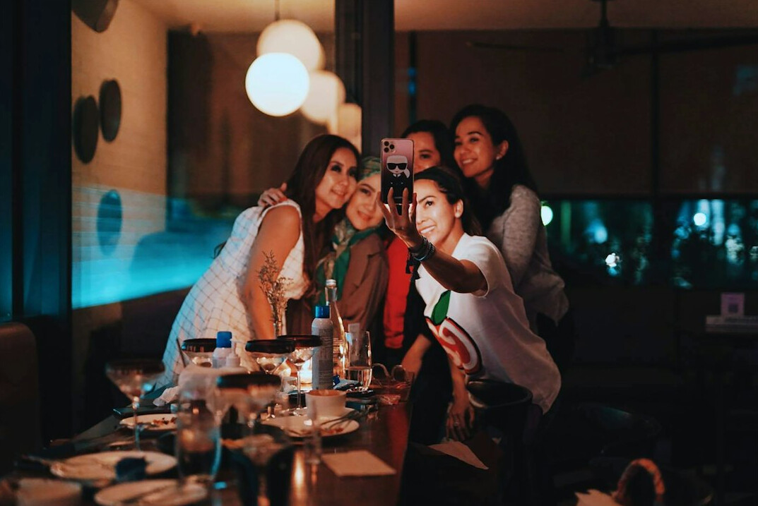 Group of media professionals discussing scripts and photographs at a table